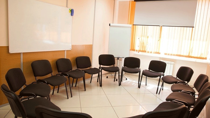 Комната для тренинга: стулья стоят по кругу, на заднем фоне доска
